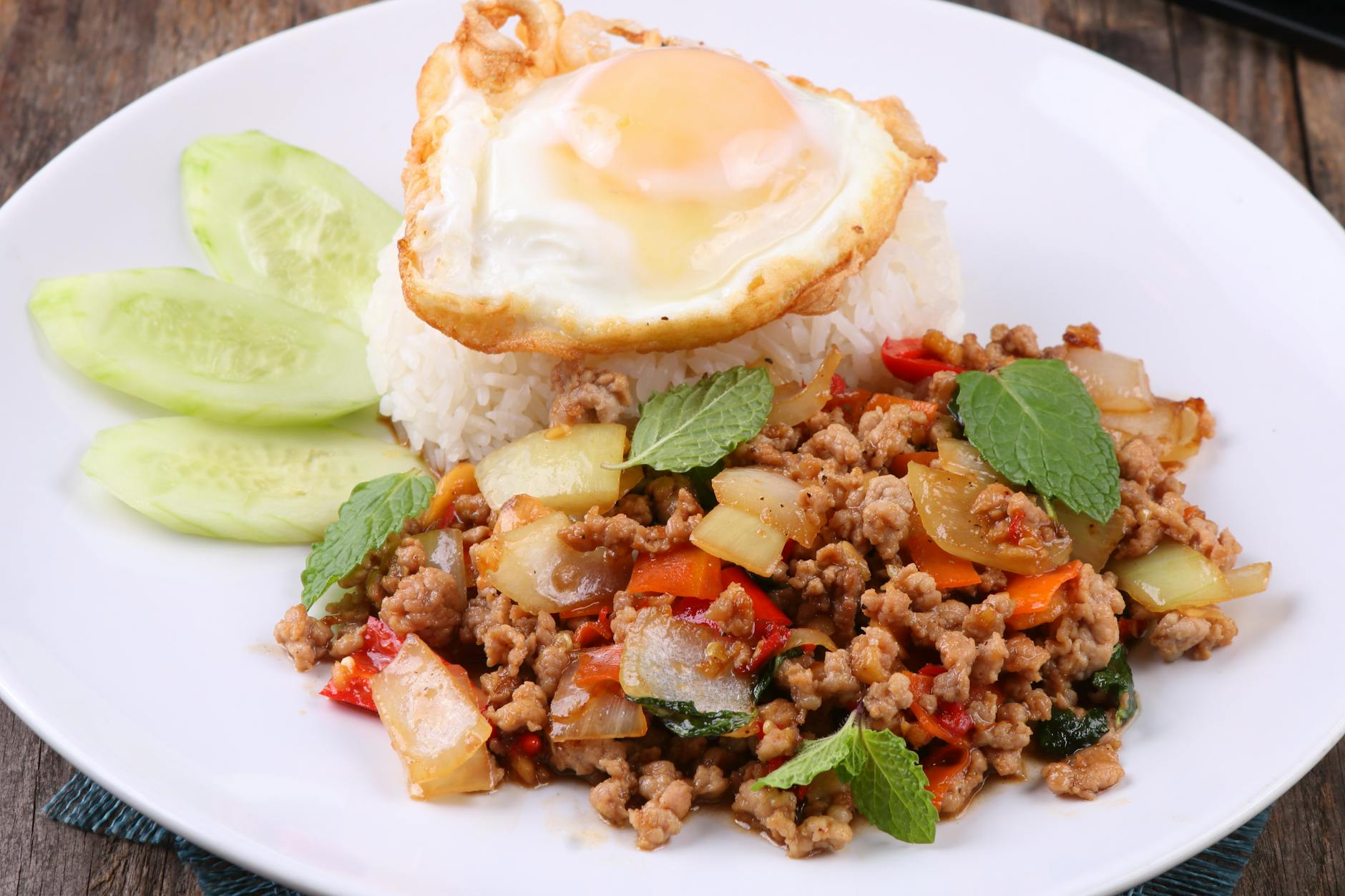 Tajskie danie z mieloną wieprzowiną, ryżem i jajkiem sadzonym na talerzu