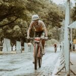 Kolarz podczas triathlonu jedzie w deszczu