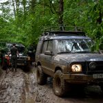 SUV-y pokonujące błotnistą leśną drog